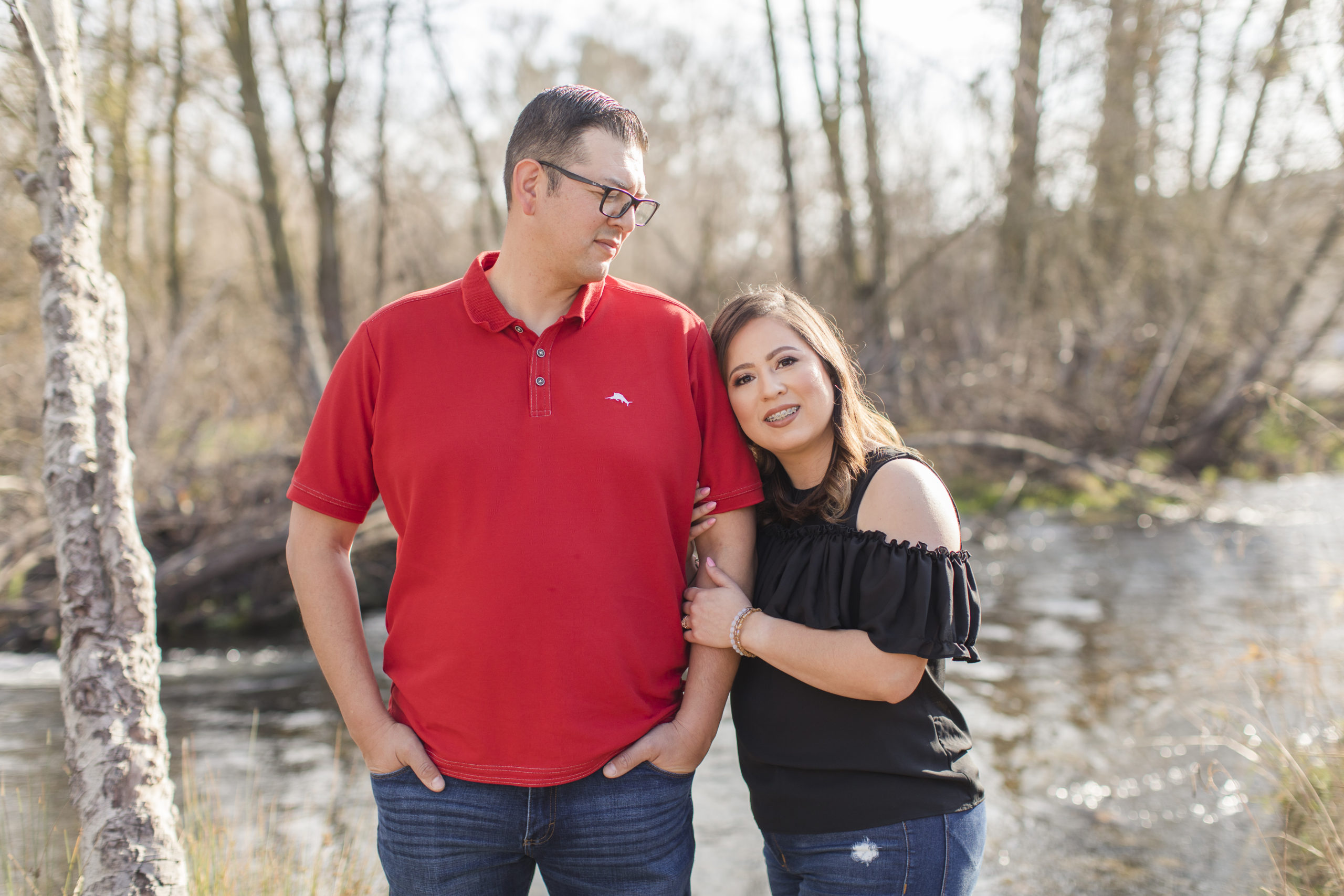 engaged couple by creek